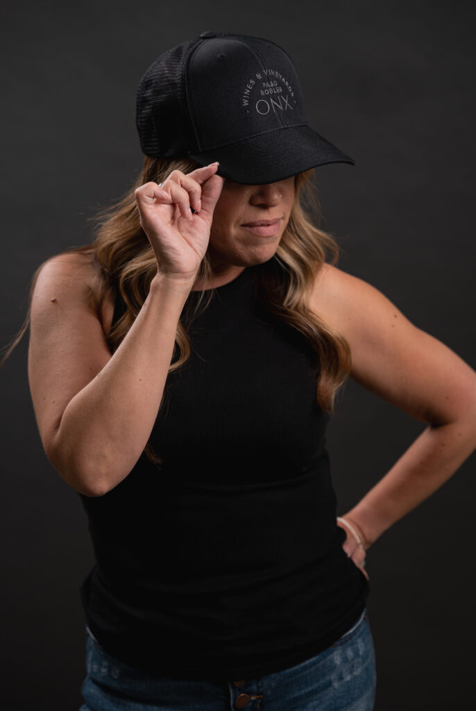 Image of http://Woman%20looking%20to%20the%20side%20while%20wearing%20a%20black%20hat%20with%20the%20ONX%20logo