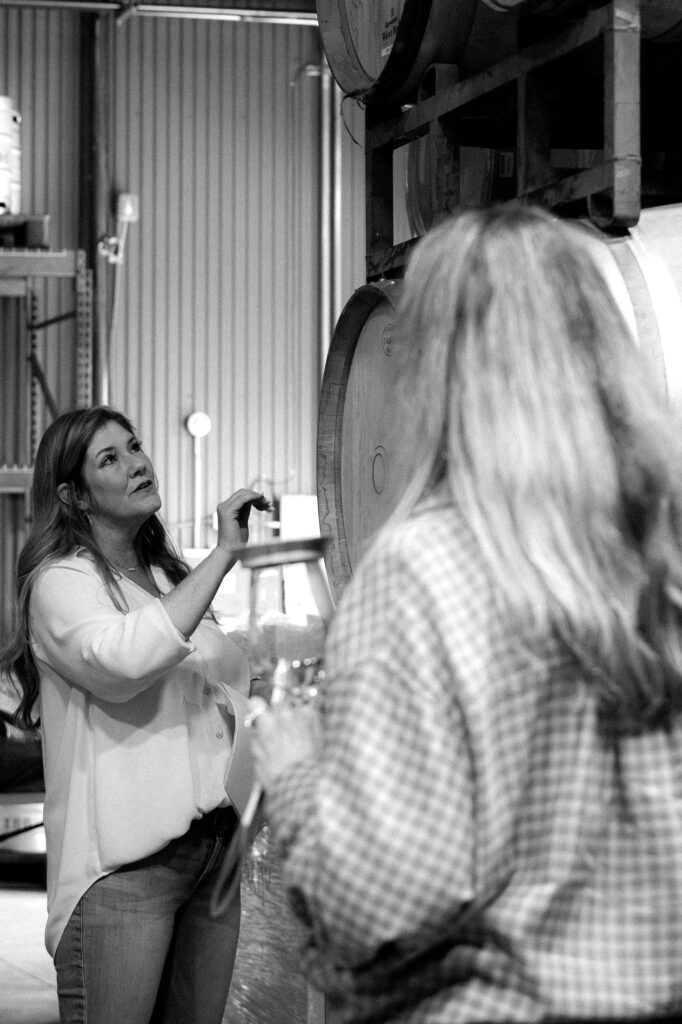 Two guests tasting wine in the ONX cellar, black and white