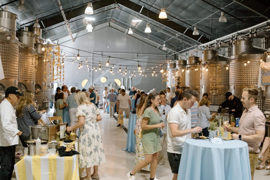 Guests gathered under string lights at an ONX club celebration in the winery