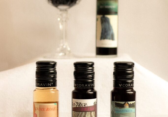 ONX small-format tasting bottles lined up beside a glass of red wine